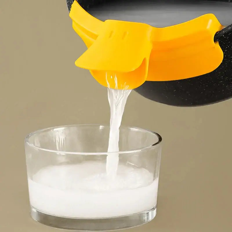 Bright yellow silicone duck beak funnel attached to a black pot spout decorbites duck beak kitchen nozzle