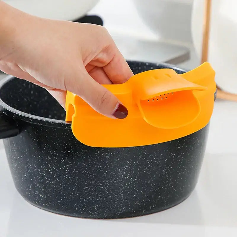 Bright orange silicone pot lid grip with built-in strainer paired with yellow decorbites duck beak funnel kitchen nozzle