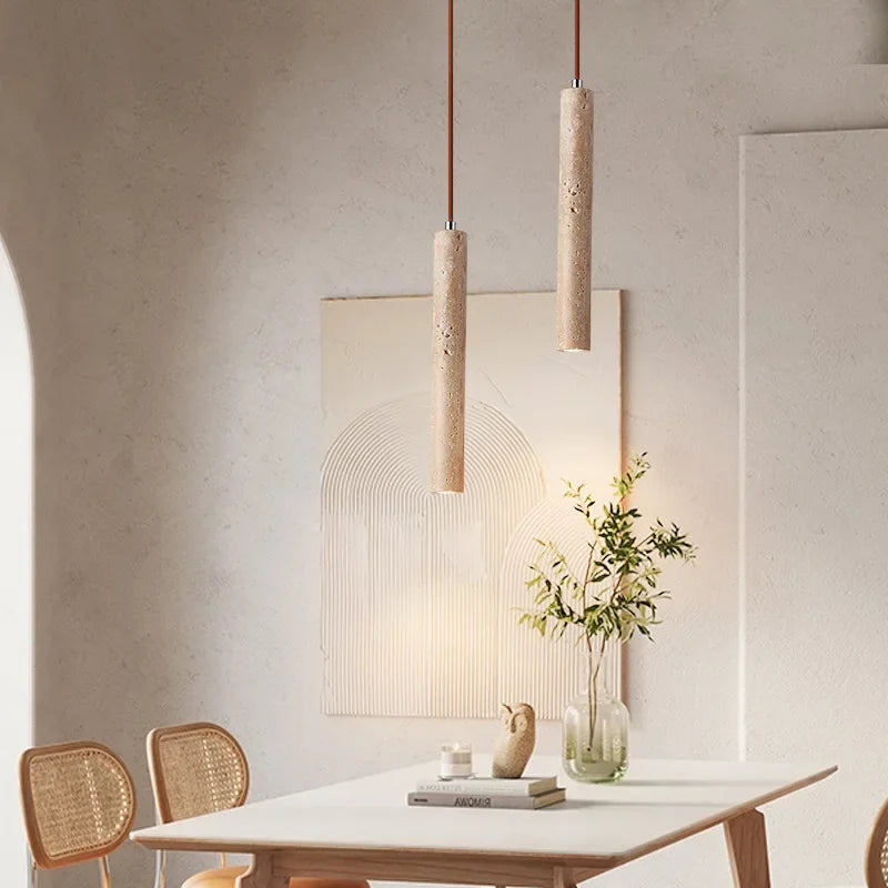Yellow stone pendant light with two beige textured concrete stone pendant lights suspended by brown cords for bedroom