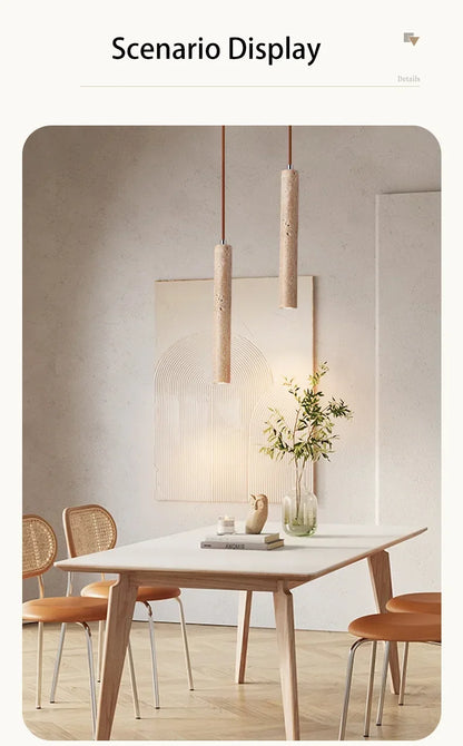 Two cylindrical stone pendant lights with a textured light beige finish hang in a bedroom setting