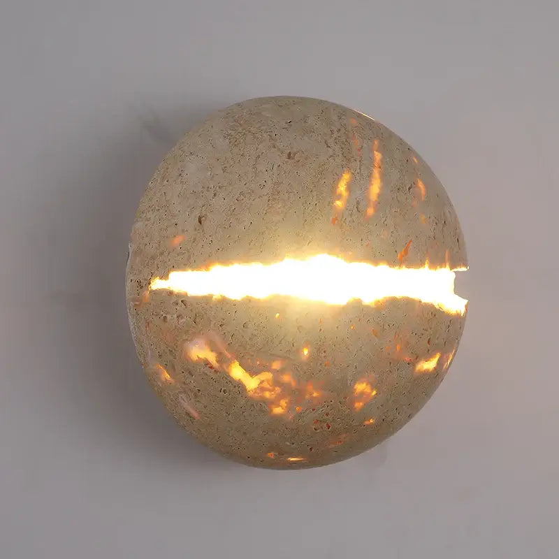 Yellow travertine dino egg stone wall lamp with textured concrete sconce and glowing horizontal slit for bedroom decorbites dino egg