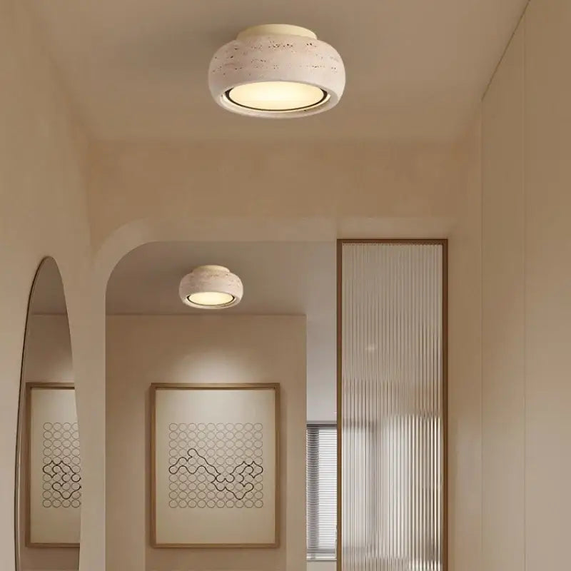 Cream-colored yellow travertine ceiling light with textured circular design and warm glow for bedroom decorbites led yellow