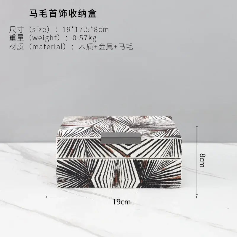 Rectangular wooden jewelry storage box with black and white geometric pattern and metallic clasp for desktop use
