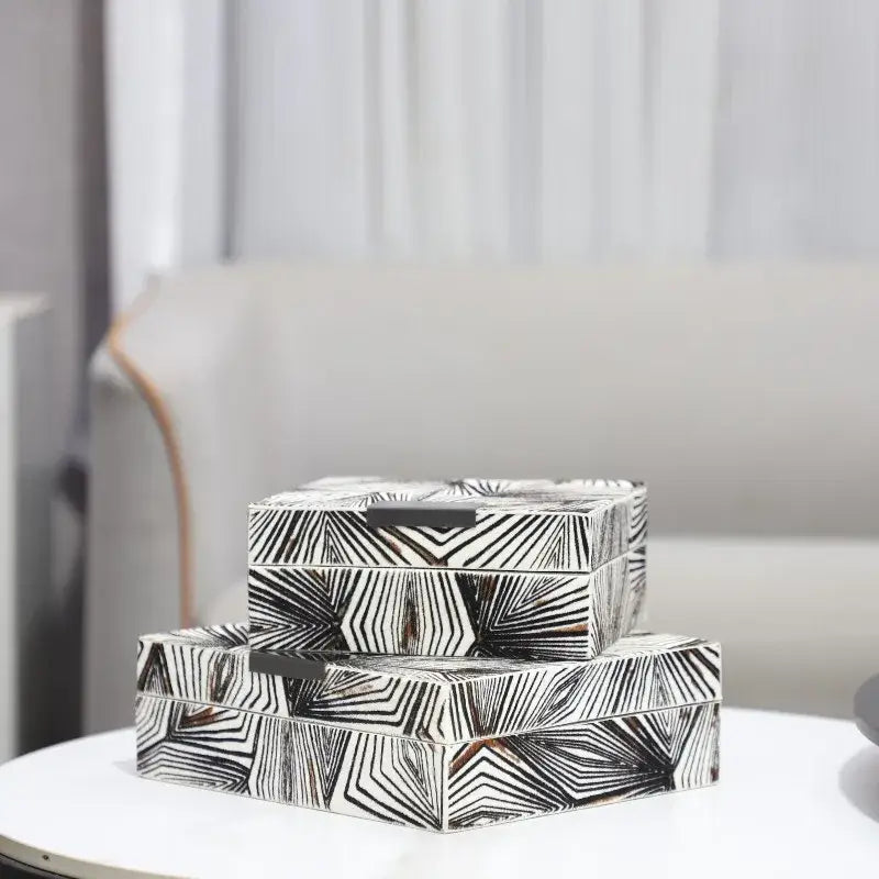 Stacked zebra black and white jewelry storage boxes with bold geometric patterns and a sleek metallic handle for desktop use
