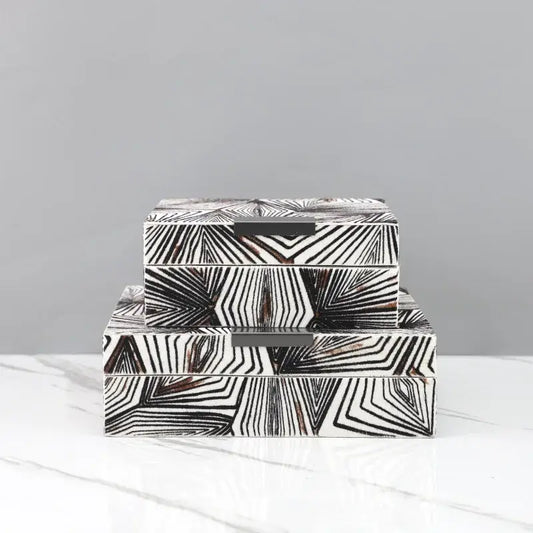Stacked zebra black and white geometric jewelry storage box with dark metal handles for desktop organization